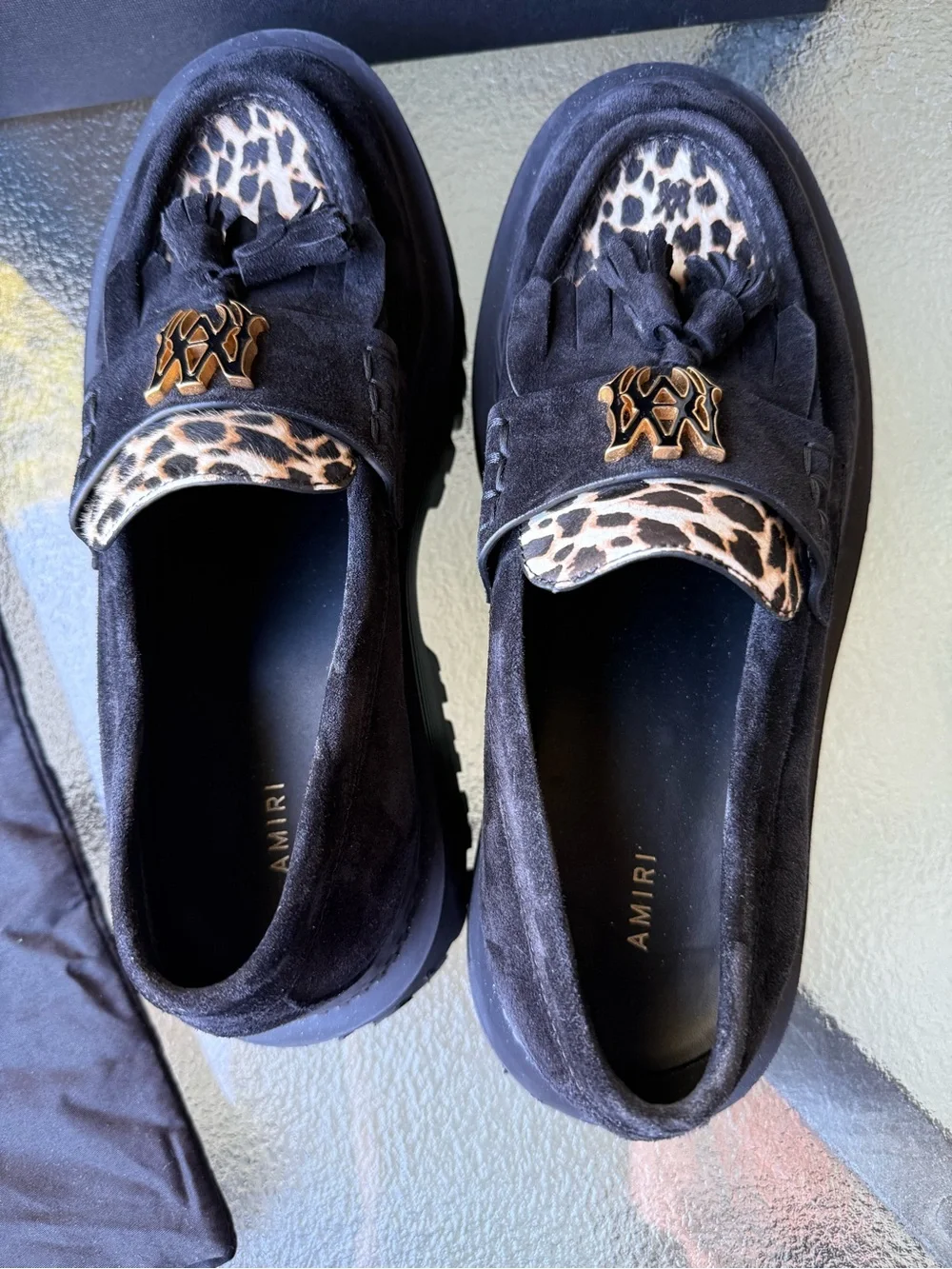 AMIRI Black Suede Tassel Loafers with Leopard Accent and Gold Crest